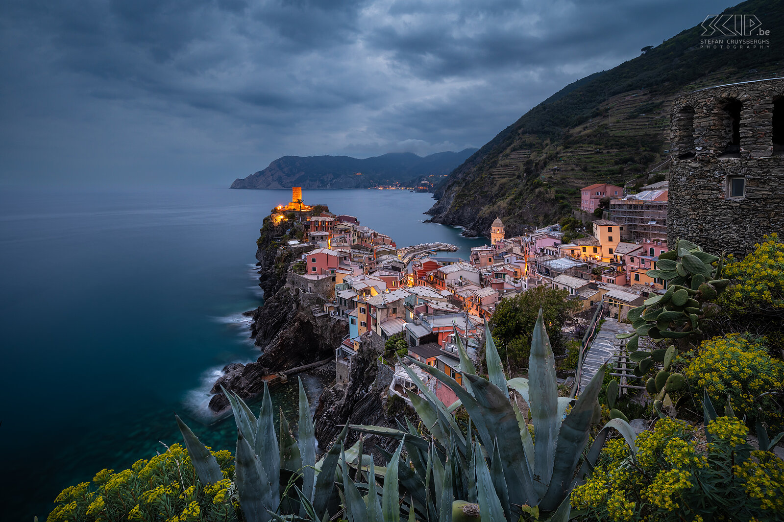 Vernazza - Blauwe uur Vernazza is een van de vijf dorpen van Cinque Terre. Het heeft prachtig gekleurde huizen en een bijzonder mooie haven en baai. Deze foto werd gemaakt vanop een bekende fotolocatie op een helling aan de zuidkant tijdens het blauwe uur op een bewolkte avond. Stefan Cruysberghs